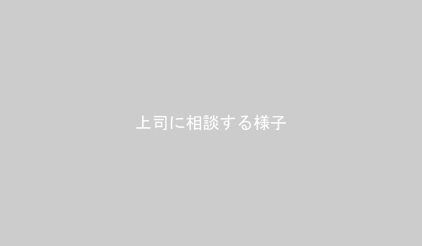 オフィスで上司と相談している若い女性の画像